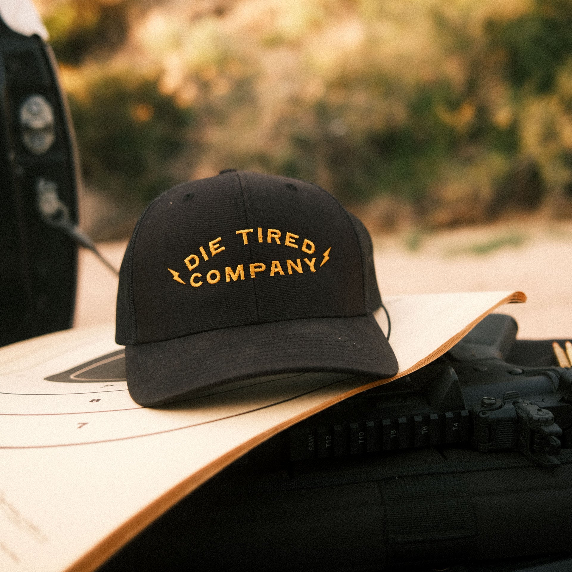 Die Tired black trucker hat with golden embroidered logo on the front
