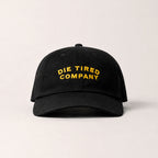 Black cap with 'Die Tired Company' text on a light gray background